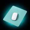 Light blue mouse pad with a white mouse on a white surface.